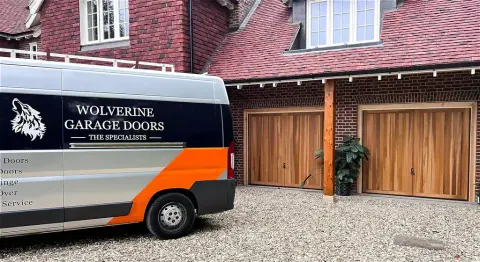 Wolverine Garage Doors branded van outside a home fitted with timber up-and-over garage doors
