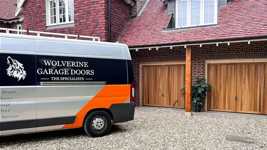Wolverine Garage Doors branded van outside a home fitted with timber up-and-over garage doors