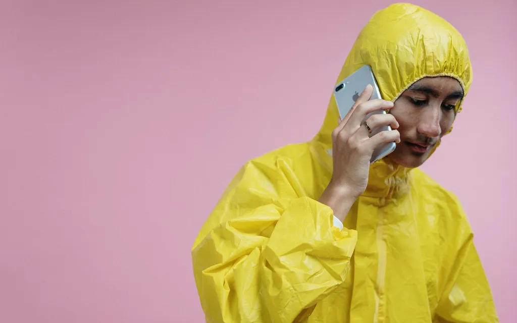 Cleaner in protective overalls taking a call on a mobile phone