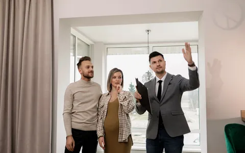 Estate agent showing a bright modern home to a couple during a viewing