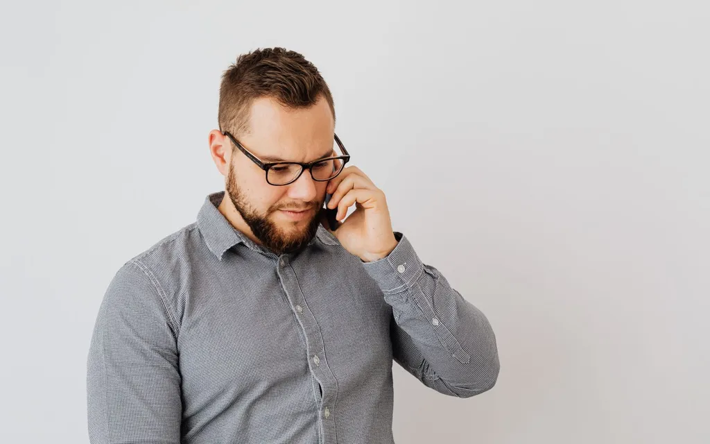 Optician in glasses taking a call on a mobile phone