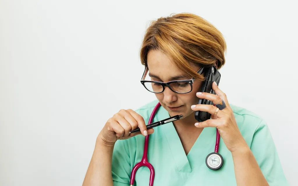 Veterinarian in scrubs taking a call on the phone
